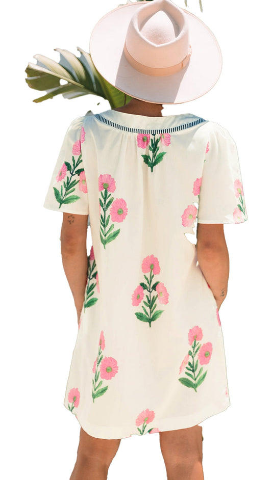 Back view of an apricot floral mini dress by LuckeLadybug with pink flowers and green leaves