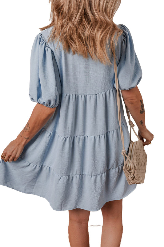 Back view of model wearing LuckeLadybug H Line blue shirt collar puff sleeve dress with tiered skirt