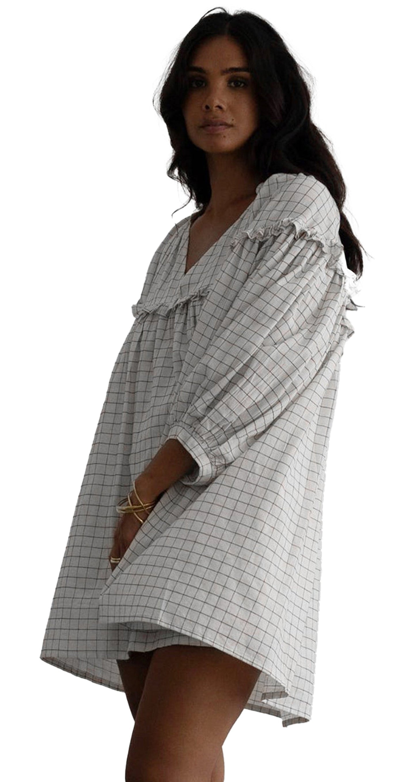 Model wearing white checkered babydoll dress with V neck puff sleeves and relaxed mini silhouette