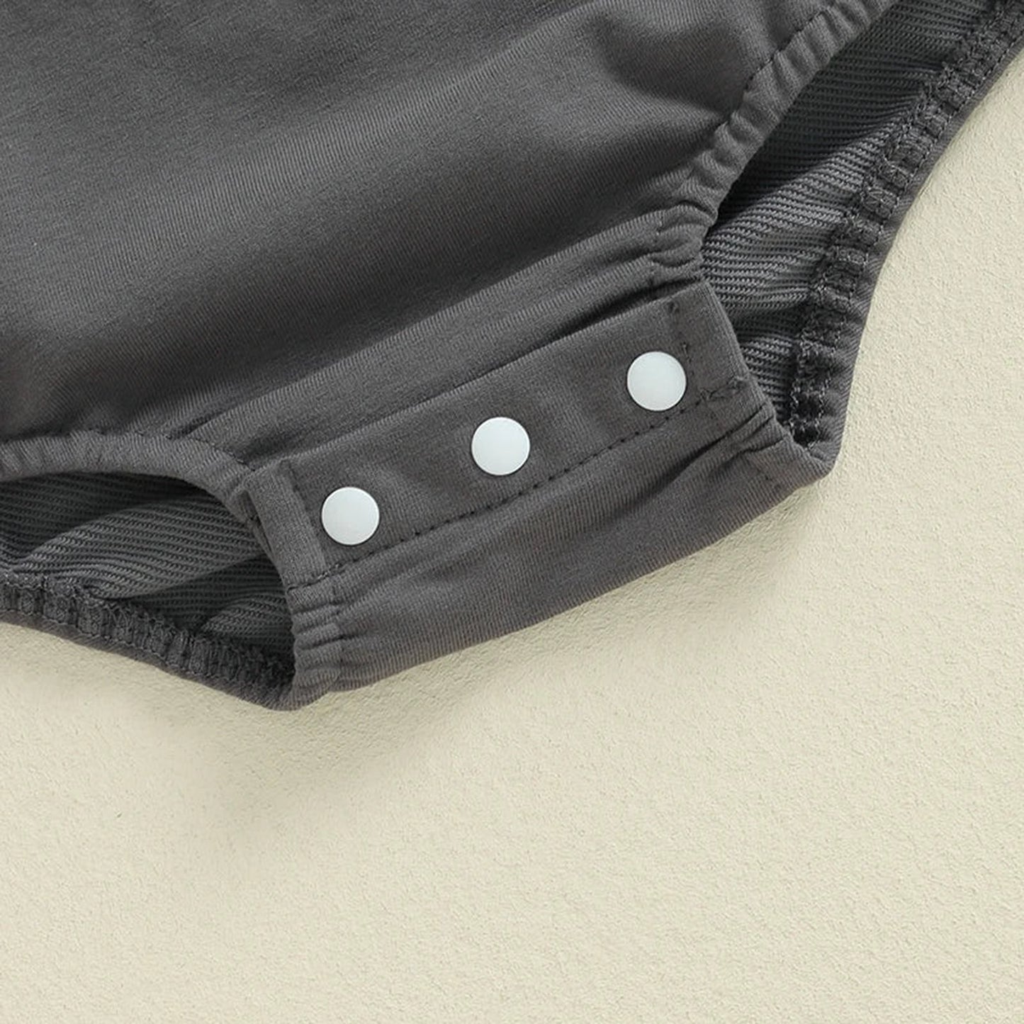 Close-up of grey baby boy Halloween romper with snap buttons for easy dressing
