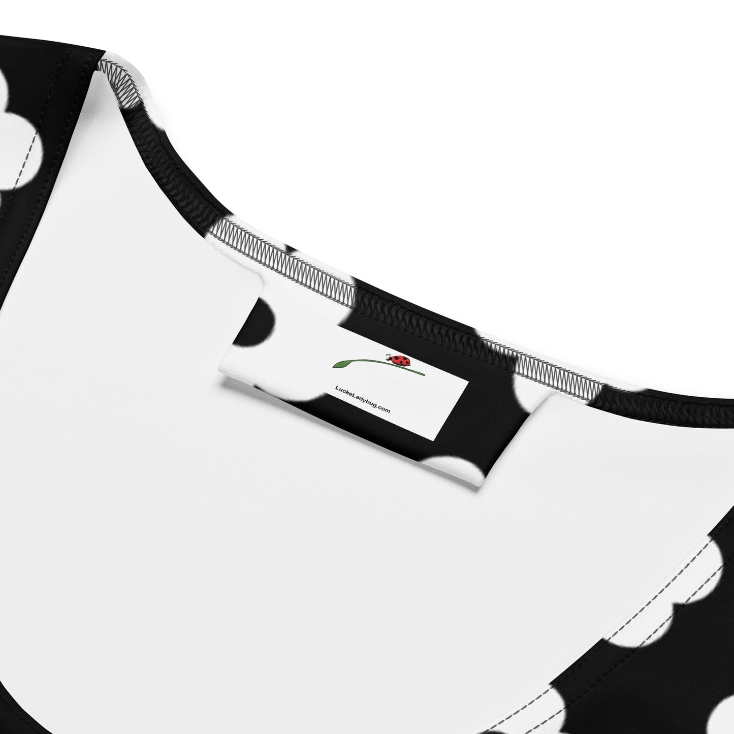 Close-up of neckline and label on LuckeLadybug black and white bodycon dress with polka dot design