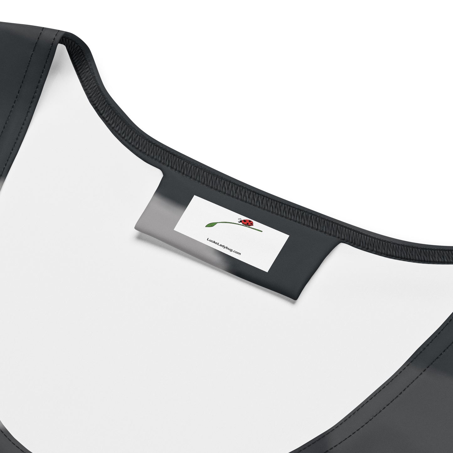 Close-up of LuckeLadybug label inside black camouflage bodycon dress neckline