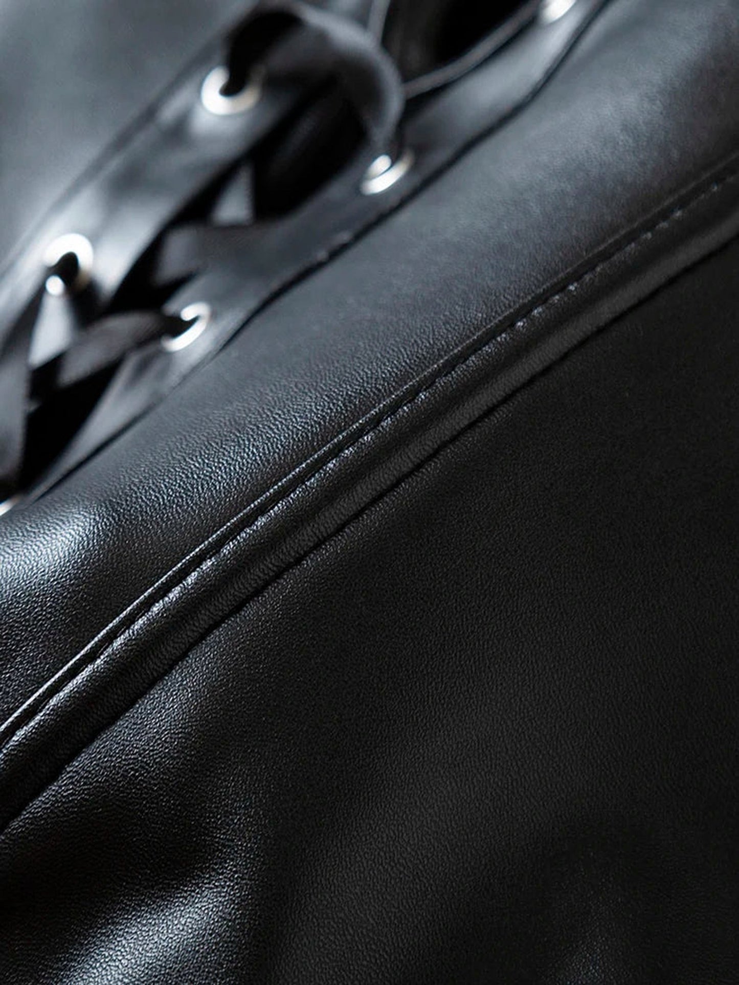 Detailed view of a black strapless corset top with lace-up design and sleek finish