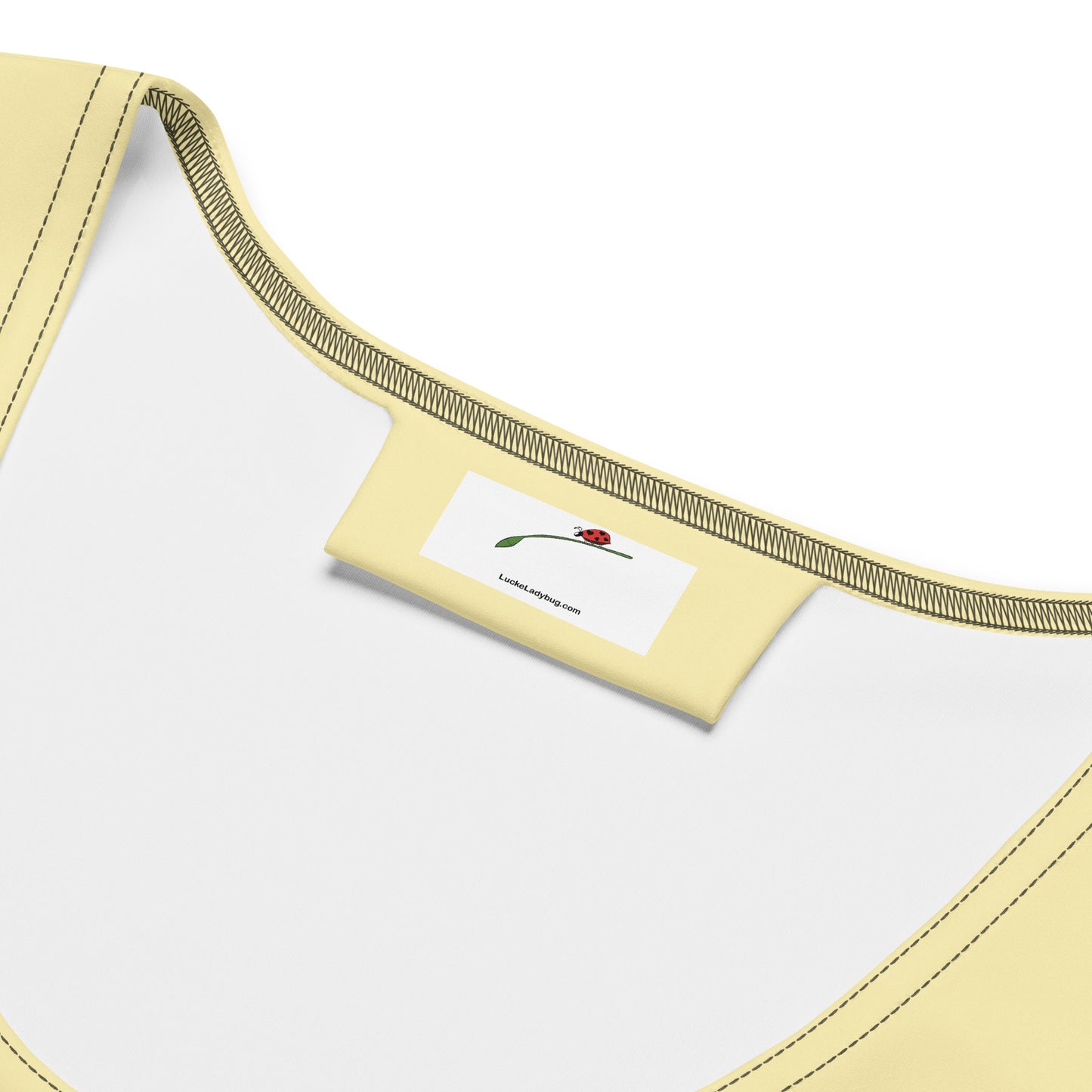 Close-up of LuckeLadybug yellow bodycon dress neckline with brand label inside black yellow bodycon dress