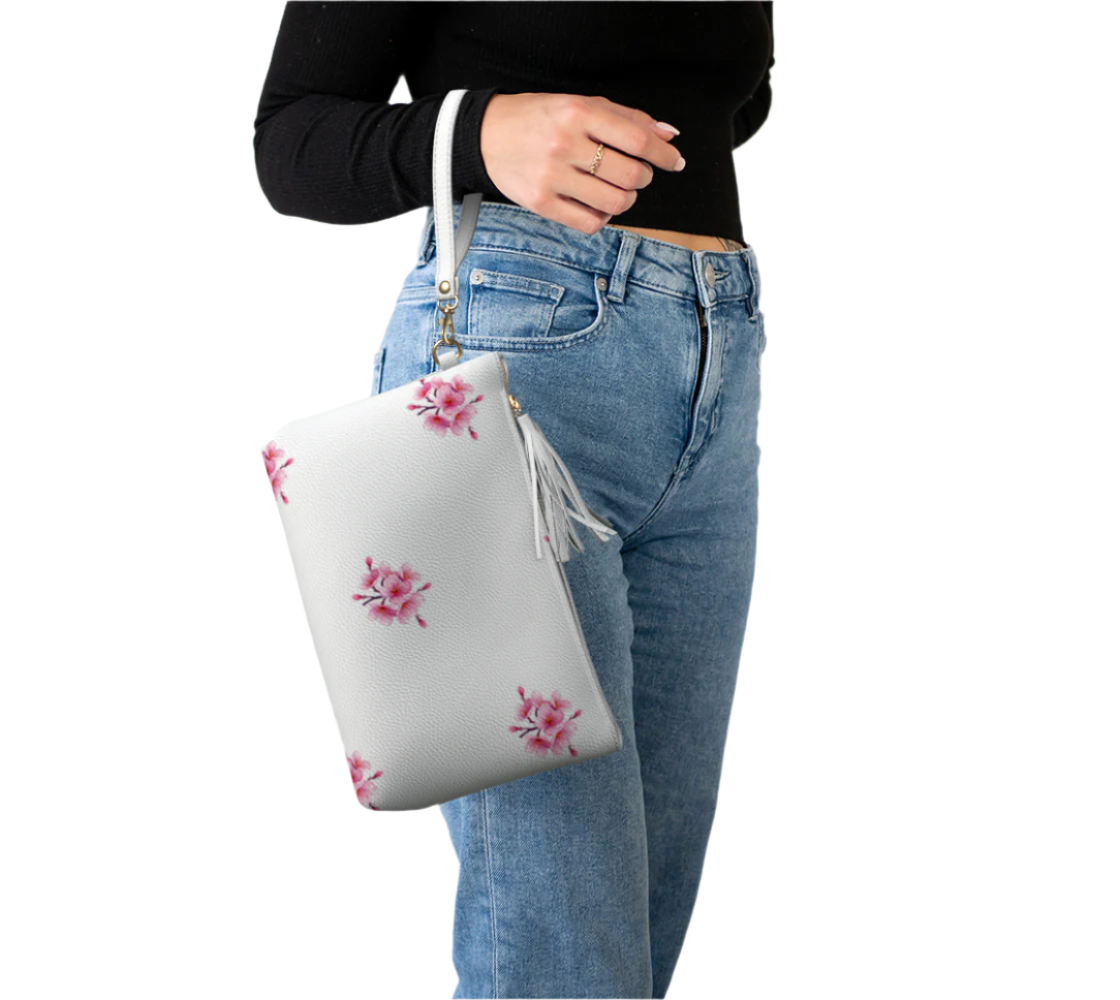 LuckeLadybug cherry blossom cosmetic bag vegan leather makeup bag with wrist strap held by woman