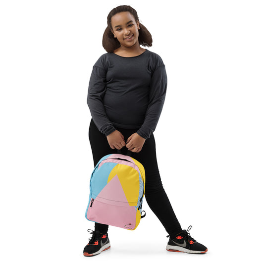 Young girl holding a colorful trendy backpack with pastel pink, blue, and yellow geometric design