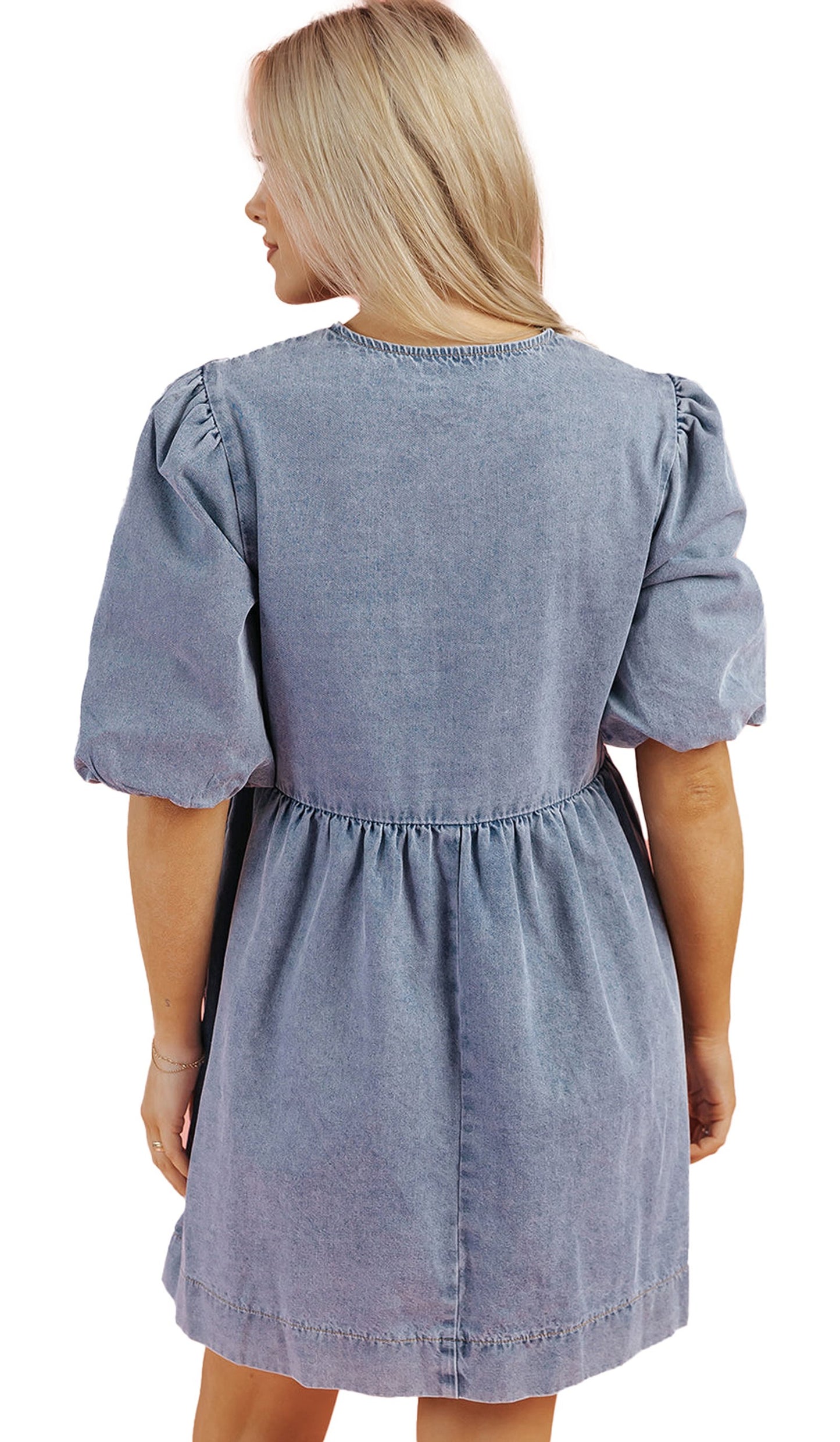 Back view of a dusk blue denim dress with puff sleeves and a cinched waist by LuckeLadybug