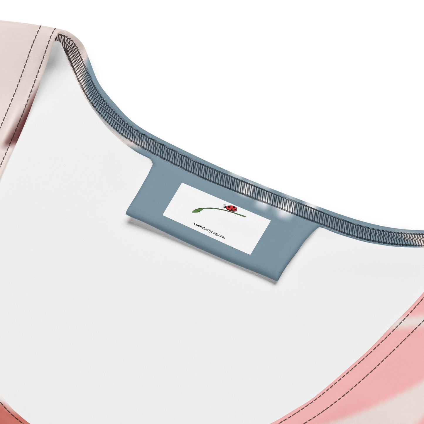 Close-up of LuckeLadybug floral bodycon dress neckline and brand label featuring a ladybug design