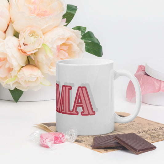 White mug with red MA lettering on the side styled as a glam ma coffee mug next to flowers and chocolates