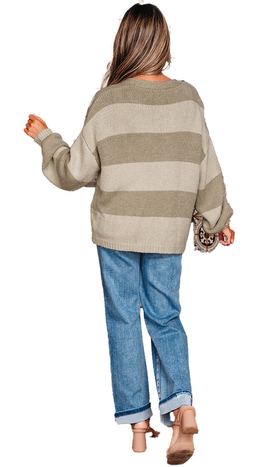 Woman wearing a khaki striped cardigan sweater with balloon sleeves and relaxed fit in a stylish setting