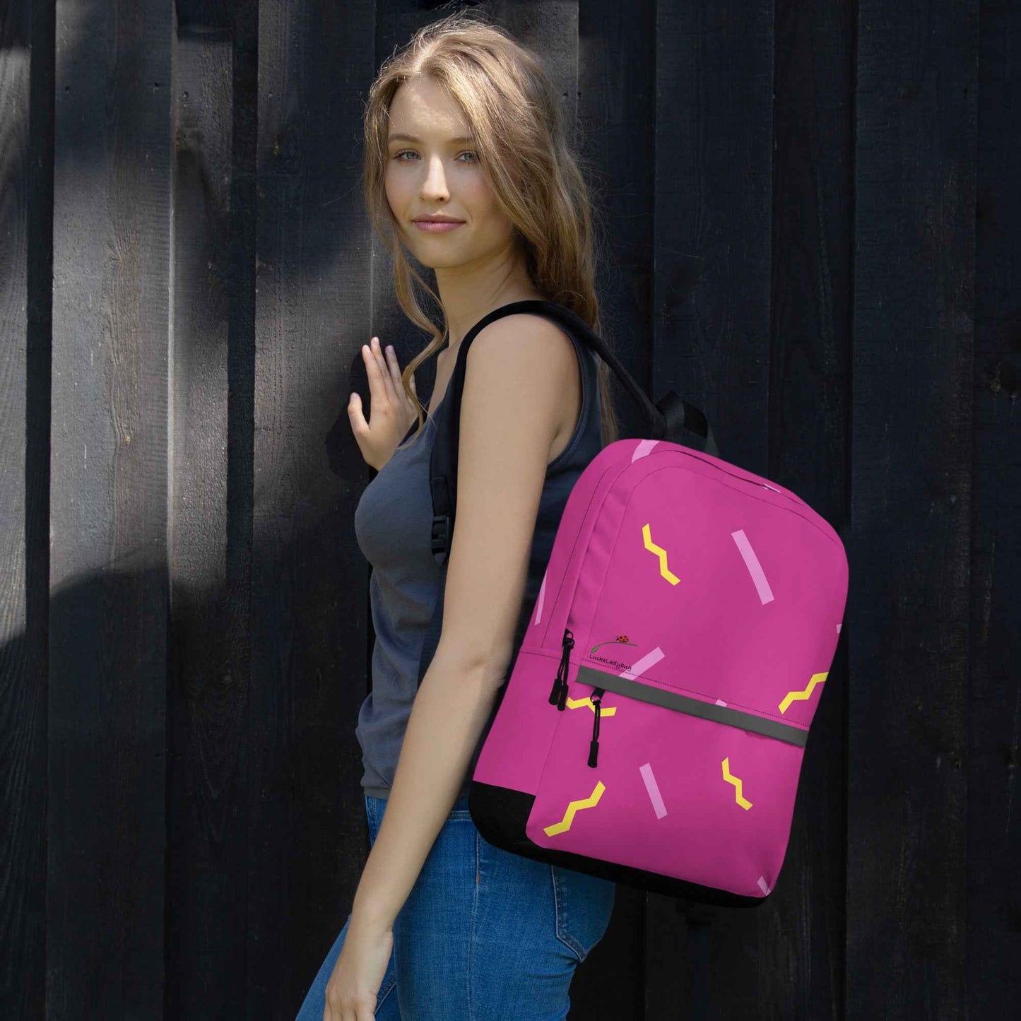 Woman wearing a pink LuckeLadybug stylish school backpack with yellow and purple patterns
