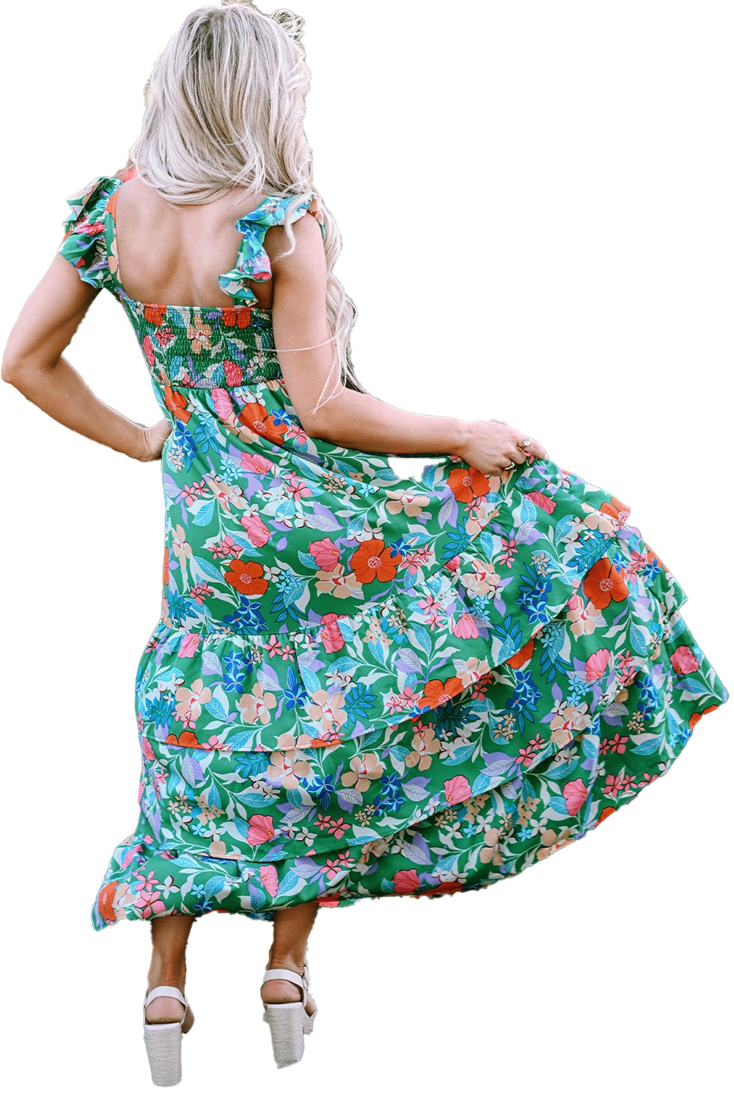 Woman in garden wearing a green floral maxi dress by LuckeLadybug with ruffle straps and tiered skirt