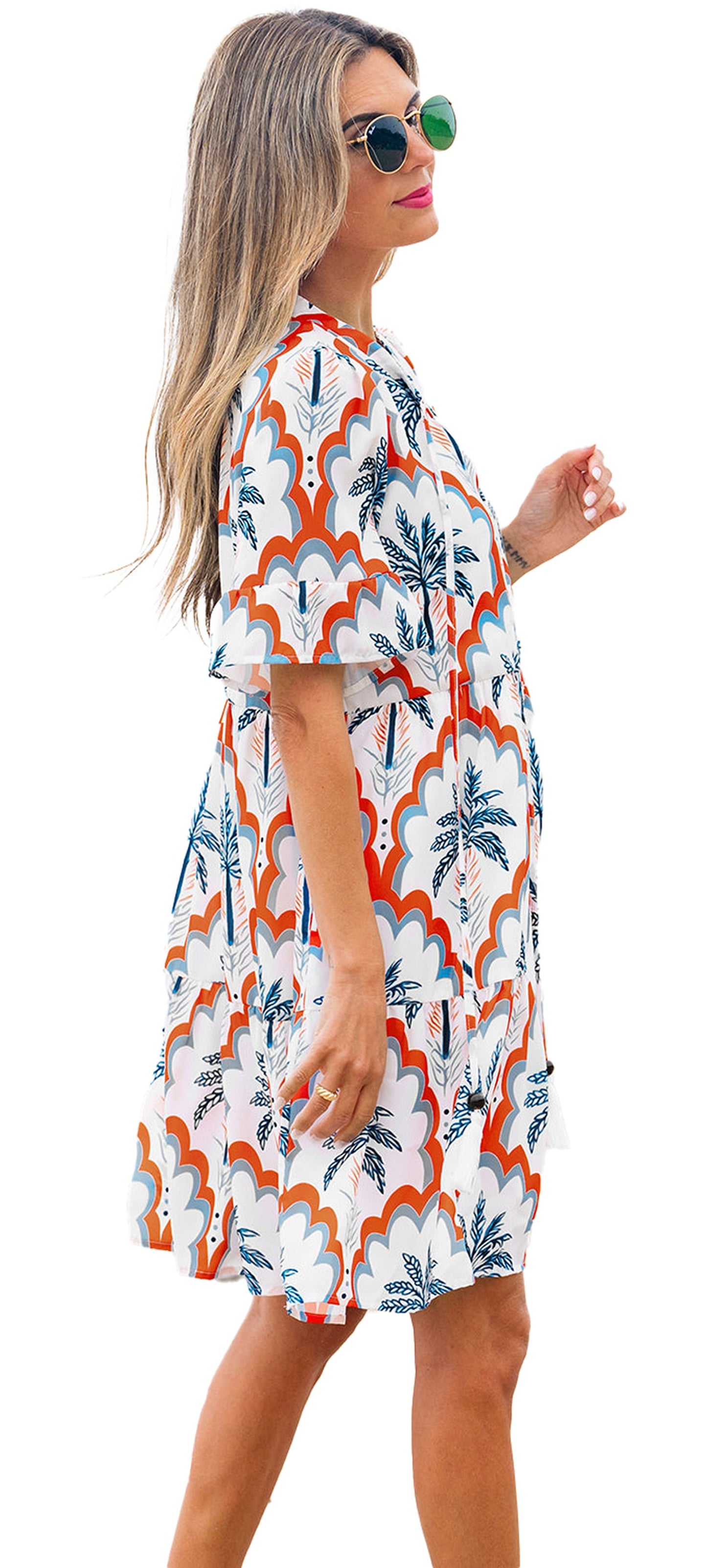 LuckeLadybug orange palm tree flowy dress on a model at the beach for a stylish summer look