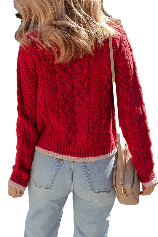 Rear view of a woman wearing a racing red cable knit cardigan paired with blue jeans