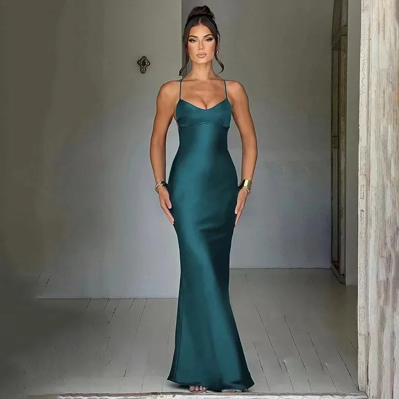 Woman wearing a sexy satin evening gown in teal with spaghetti straps for elegant occasions