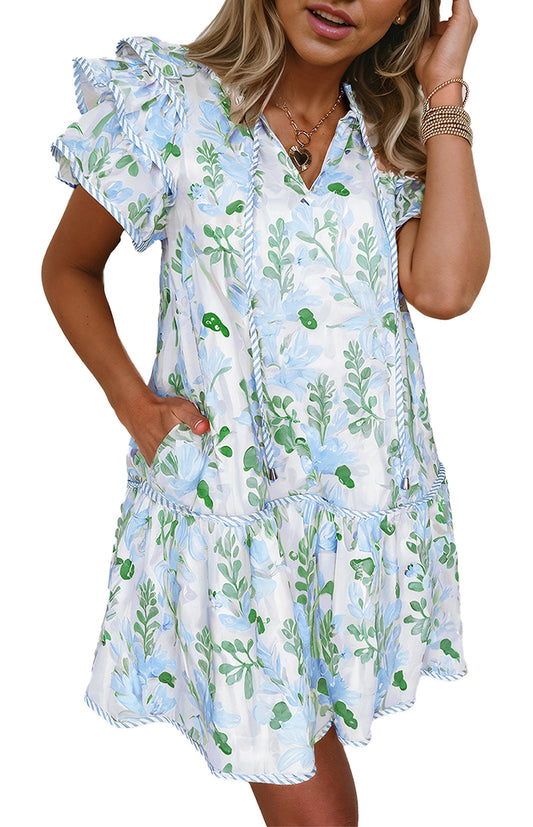 Woman wearing a sky blue floral mini dress with ruffled sleeves V neck pockets and tiered hem