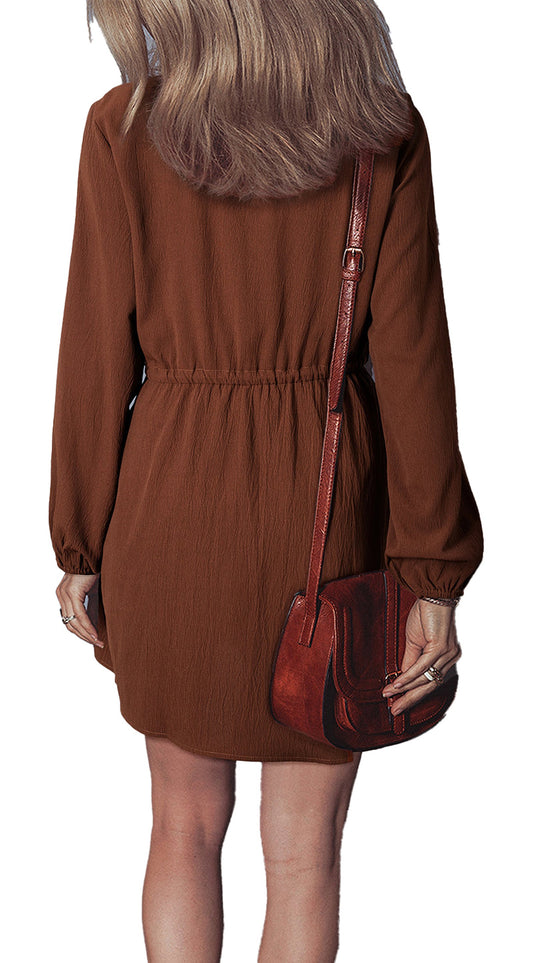 Back view of model wearing burgundy floral embroidered mini dress with long sleeves elastic waist and crossbody bag