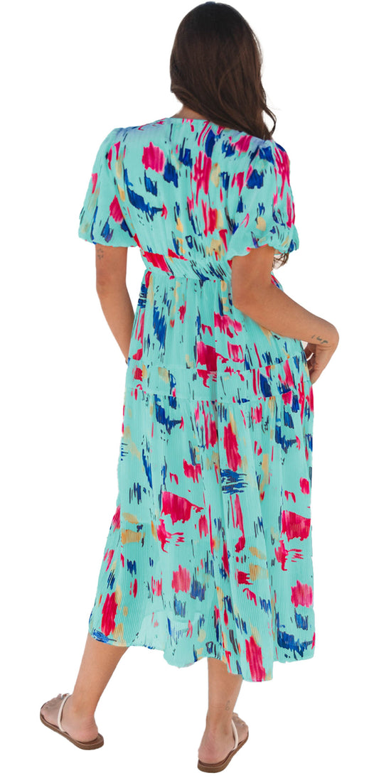 Back view of a woman wearing a sky blue abstract maxi dress with colorful patterns