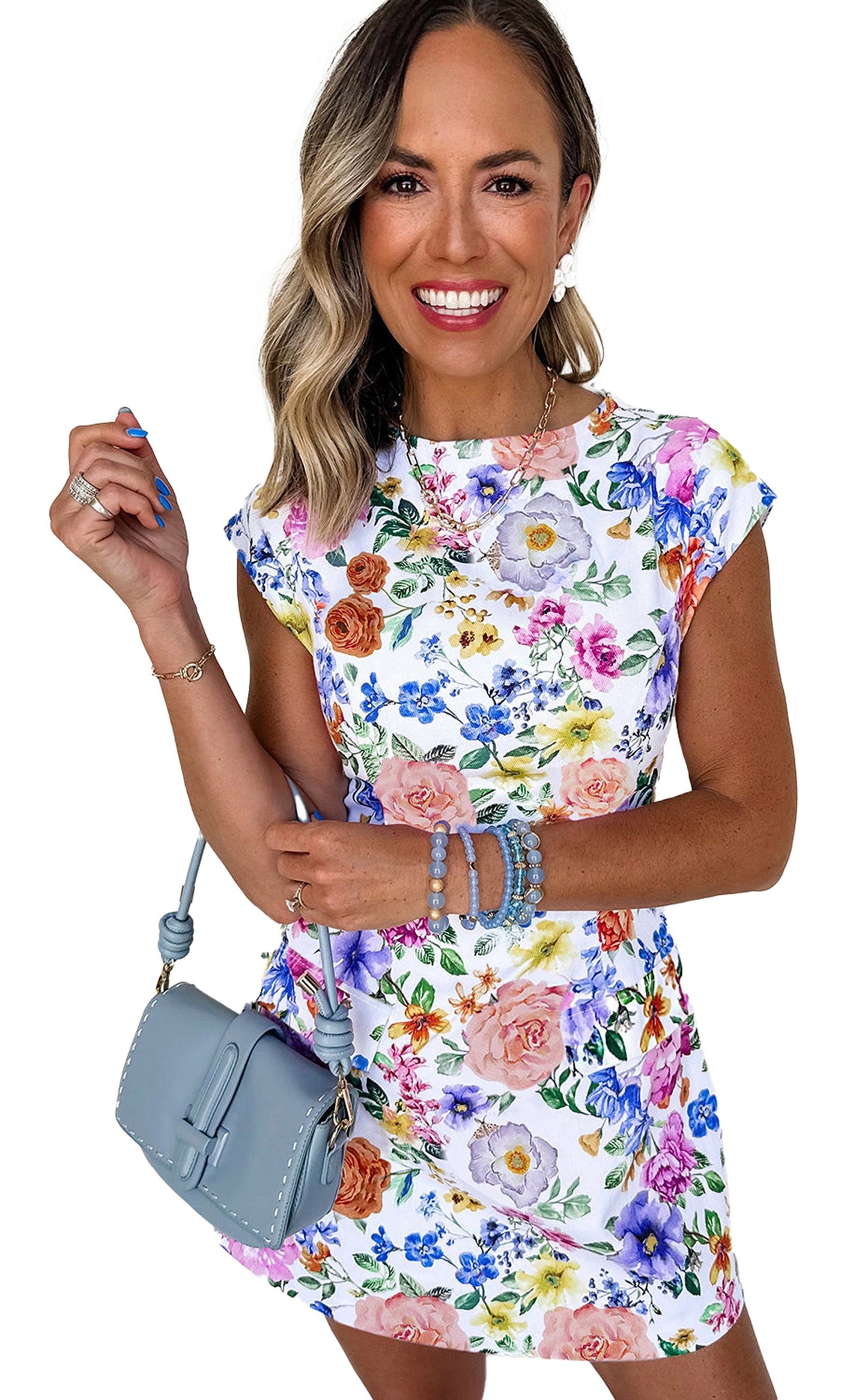 Model wearing a sky blue floral mini dress with vibrant flowers and a stylish handbag