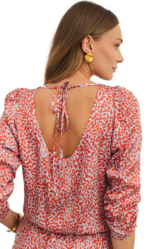 Back view of red leopard print mini dress with open tie back and puff sleeves