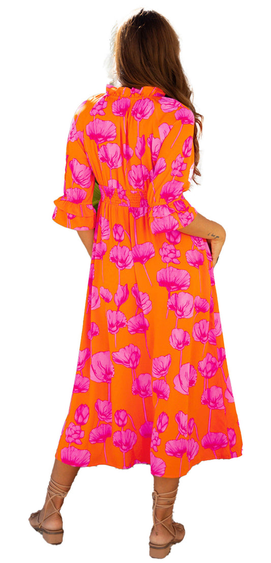 Back view of woman in orange floral smocked dress with pink floral print ruffle sleeves and tan sandals
