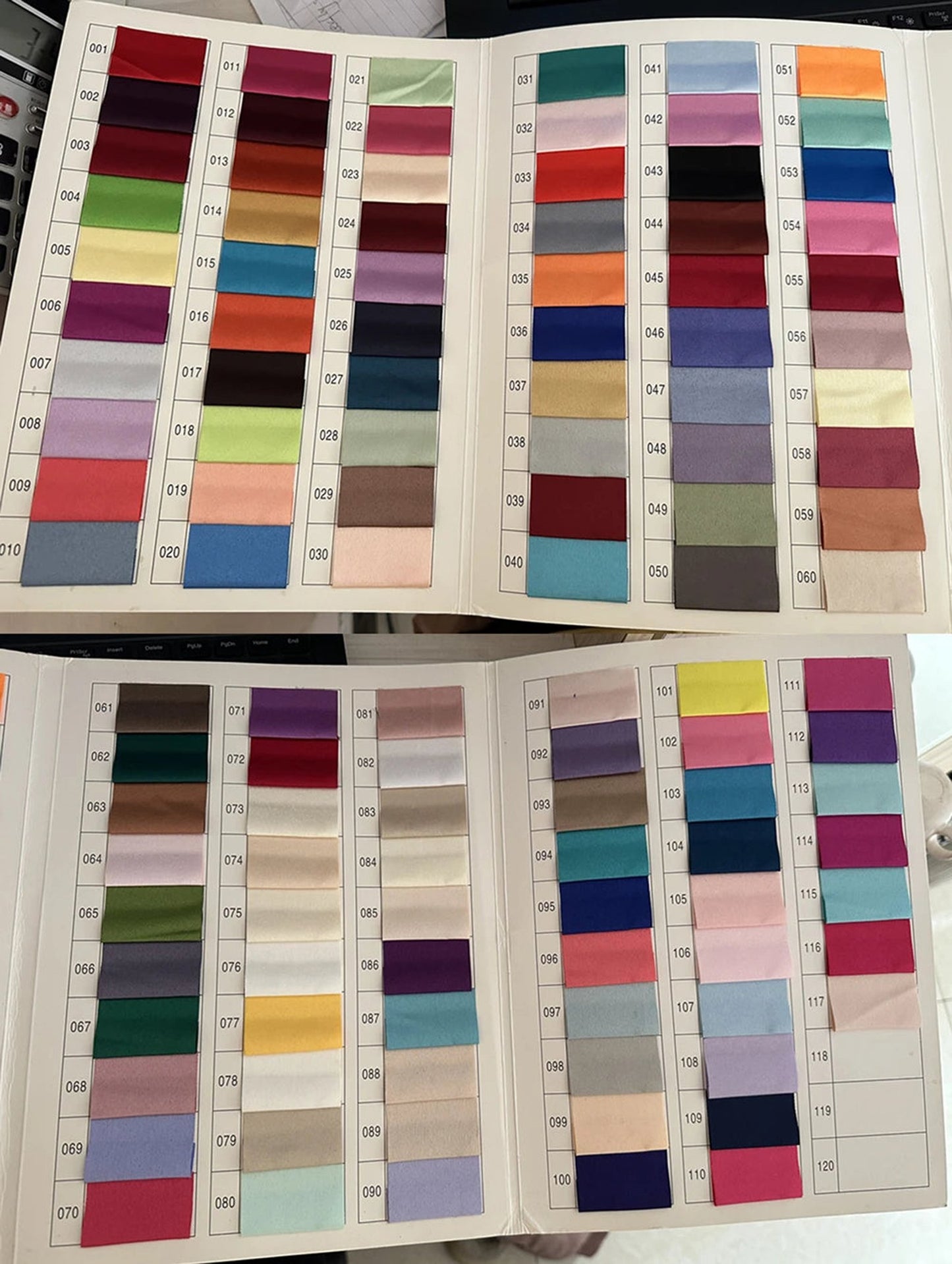 Fabric swatch book showcasing various colors for a teal mother of the bride dress with sleeves