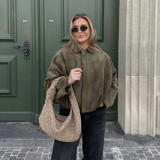 Chic women wearing a women's vintage bomber jacket styled with sunglasses and a fashionable bag