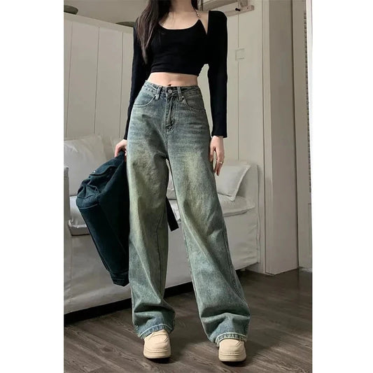 Y2K baggy jeans women in faded green denim, styled with a black crop top for a trendy look