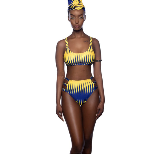 Model wearing a yellow and blue African style bikini with cutouts and matching head wrap