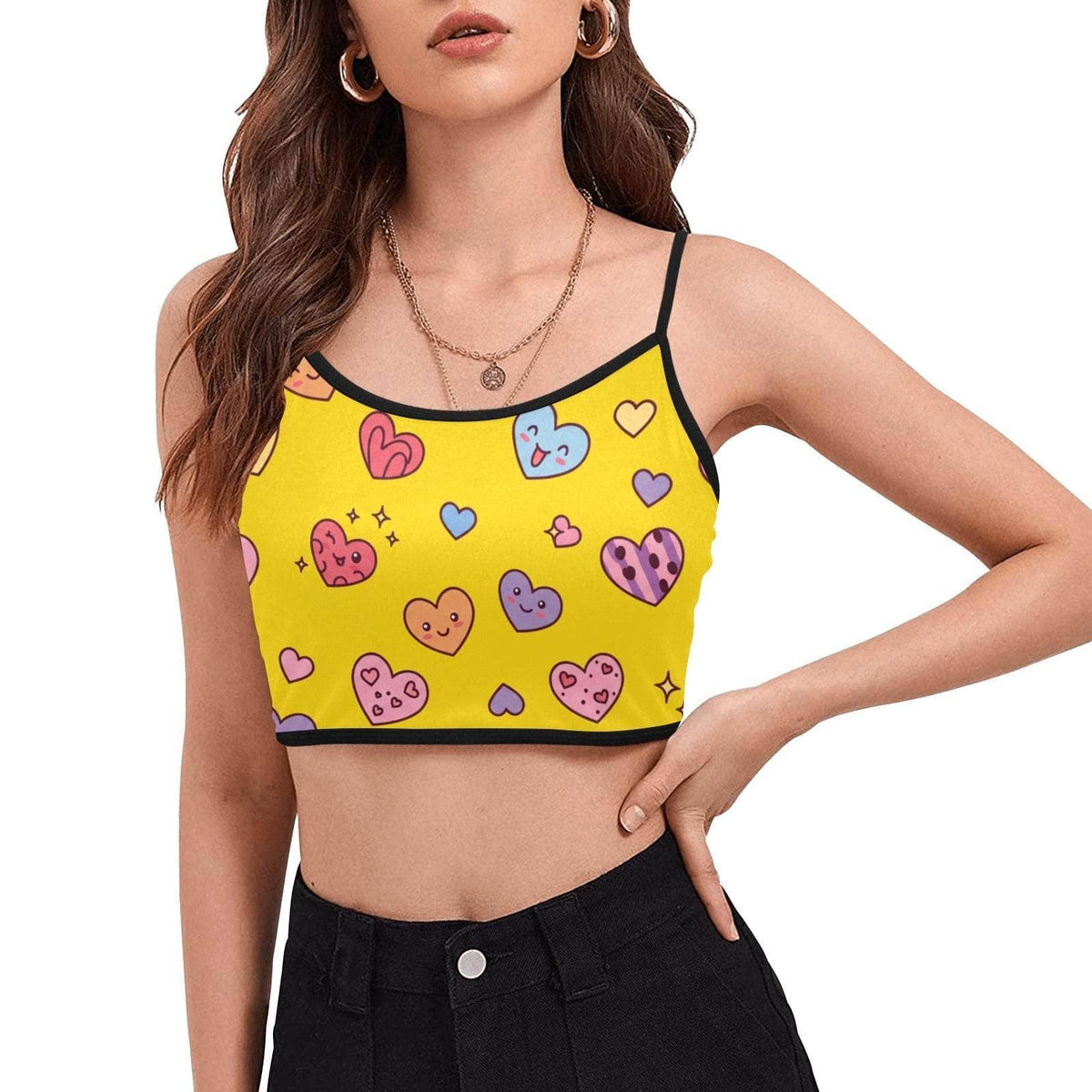 Yellow crop tops with colorful heart prints and black trim worn by model with black pants
