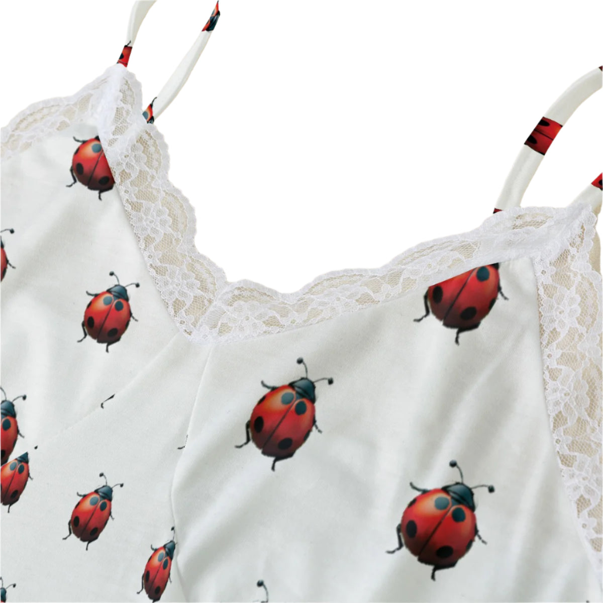 Close up of a white camisole with a ladybug print and white lace trim.