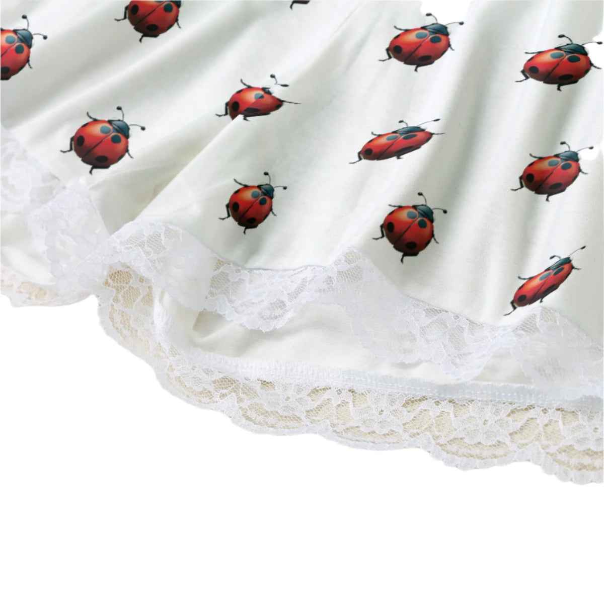 Close-up of a white garment with a ladybug print and lace trim.
