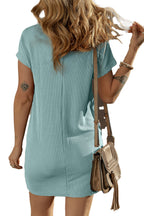 Back view of woman wearing a blue striped t-shirt dress ribbed fabric with tan crossbody bag