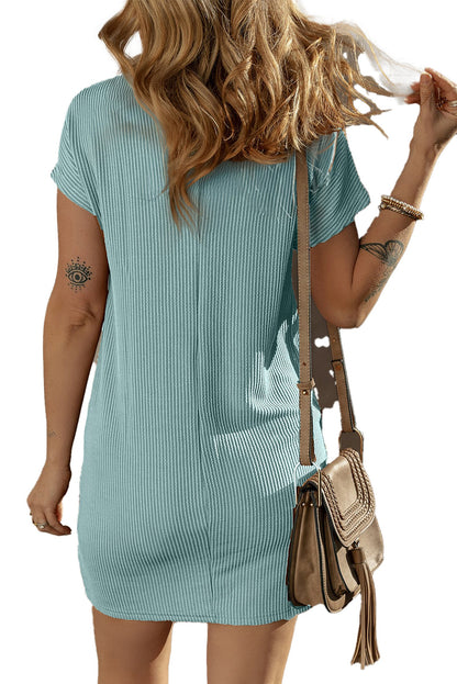 Back view of woman wearing a blue striped t-shirt dress ribbed fabric with tan crossbody bag