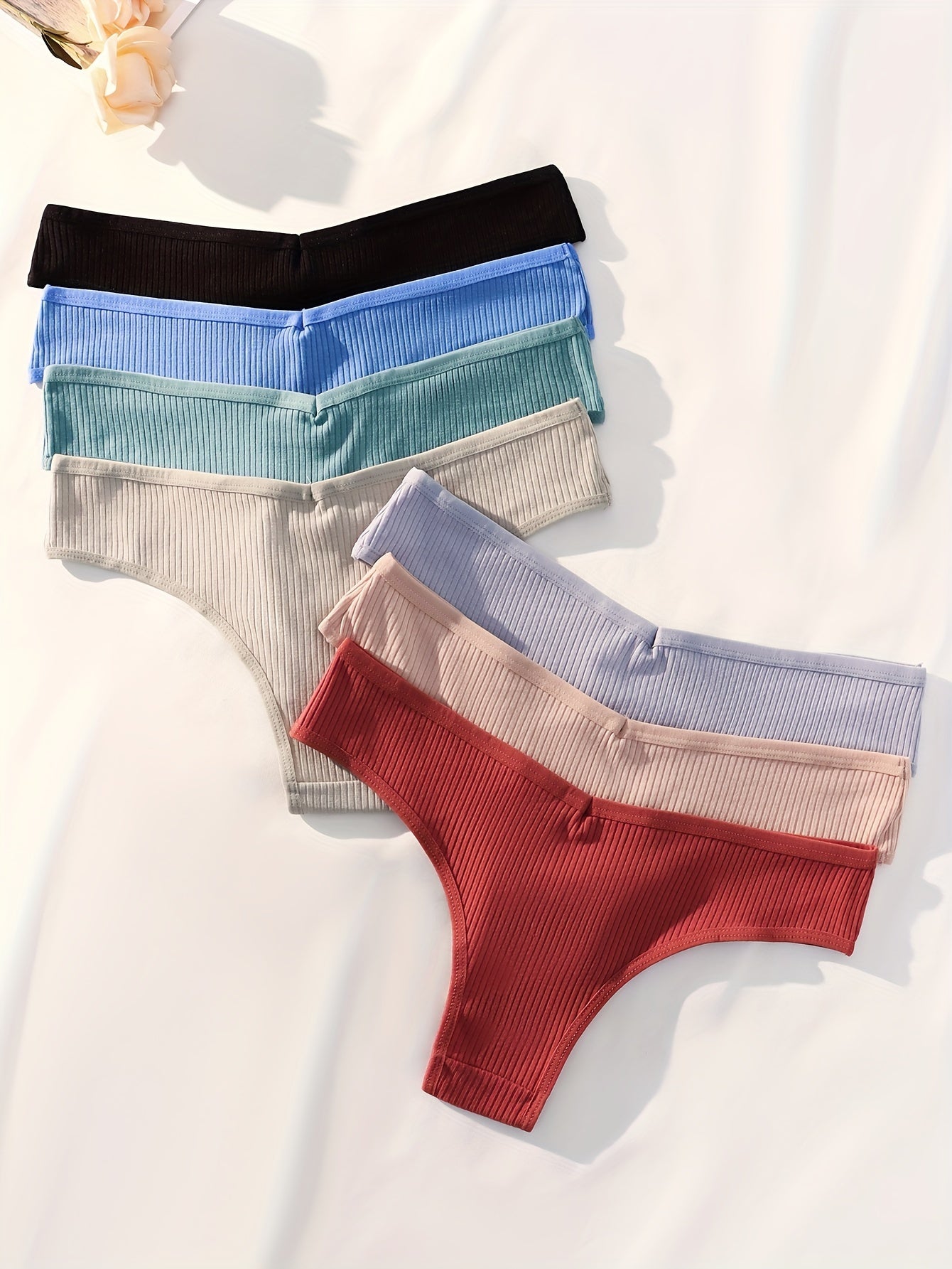 Assorted women's high-waisted hipster underwear in multiple colors arranged neatly on a soft surface