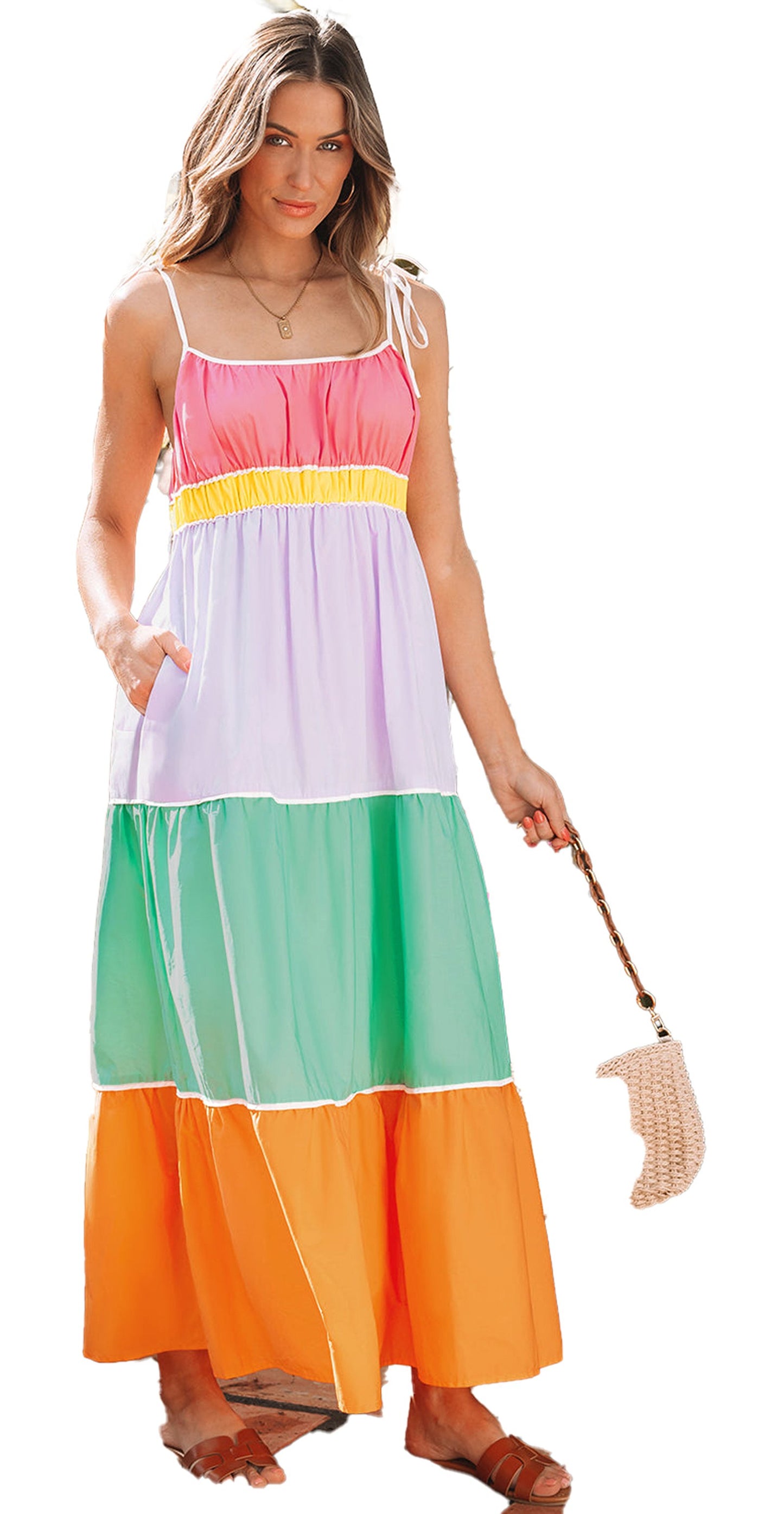 Model wearing multicolor colorblock maxi dress with tie straps smocked bodice side pockets and straw bag in tropical patio