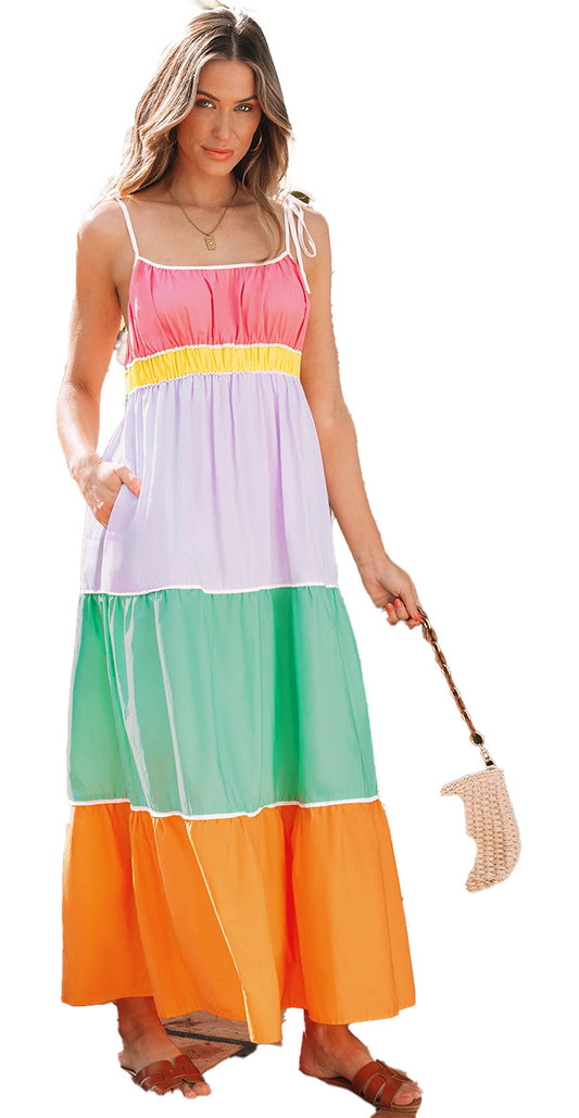 Model wearing multicolor colorblock maxi dress with tie straps smocked bodice side pockets and straw bag in tropical patio