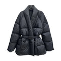 A black puffer jacket with a shawl collar and a matching elastic belt, displayed on a hanger in a clothing store.
