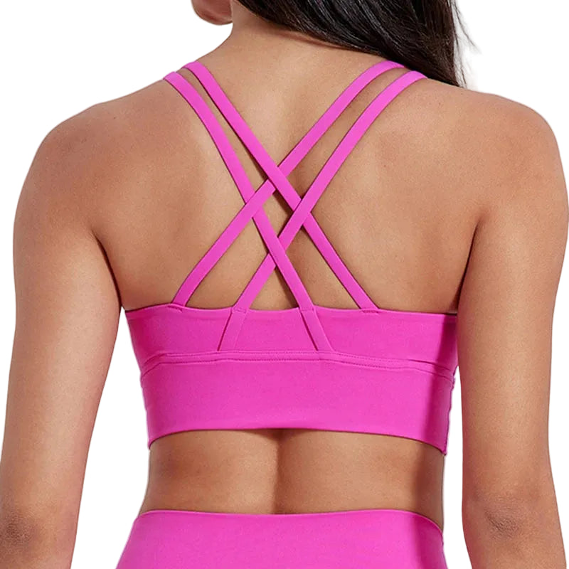 Pink sports bra with criss-cross back design on a plain background