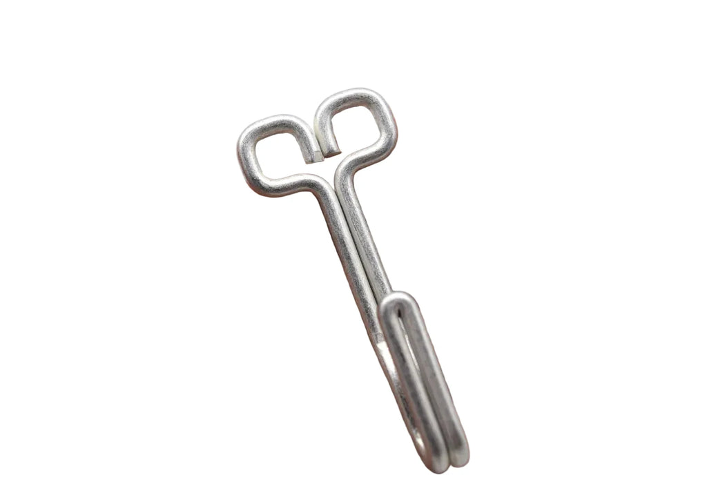 A silver metal key-shaped tool resting on an open hand against a plain white background.