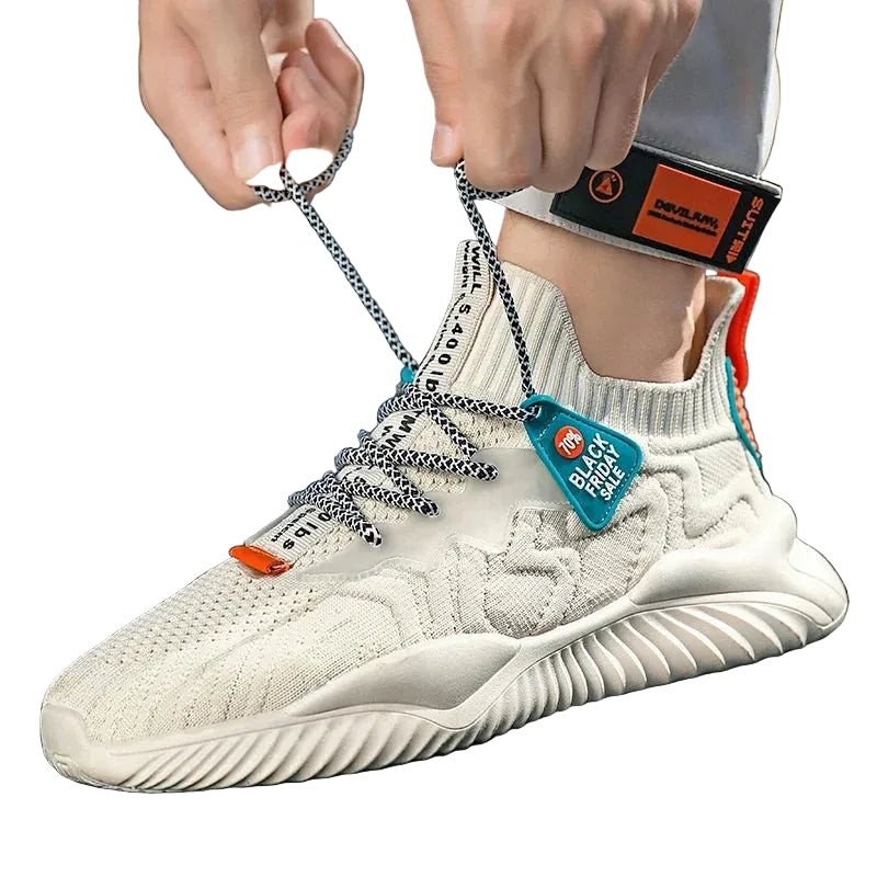 White sneaker with orange accents being tied on a person's foot.