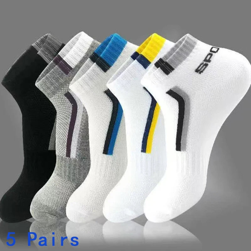 Five pairs of low-cut athletic socks fanned out against a gray gradient background. The socks come in black, gray, white, blue, and yellow colorways, each featuring a striped cuff and a curved stripe detail on the side.