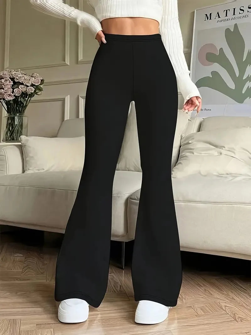 Person wearing black flared pants in a living room setting