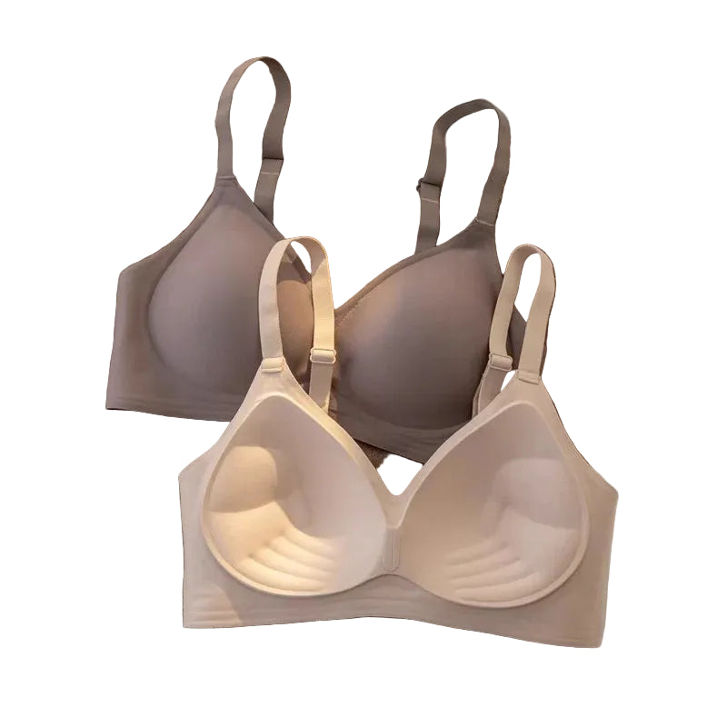 Beige bra displayed on a textured surface with a brown sweater and white fabric in the background.