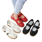 Red, white, and black shoes on a wooden surface with grass in the background