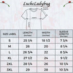 A size chart graphic for Lucke Ladybug t-shirts, featuring a simple line drawing of a short-sleeve t-shirt with labeled measurements and a table listing shirt sizes S through 3XL with corresponding length, width, and sleeve length measurements in inches.