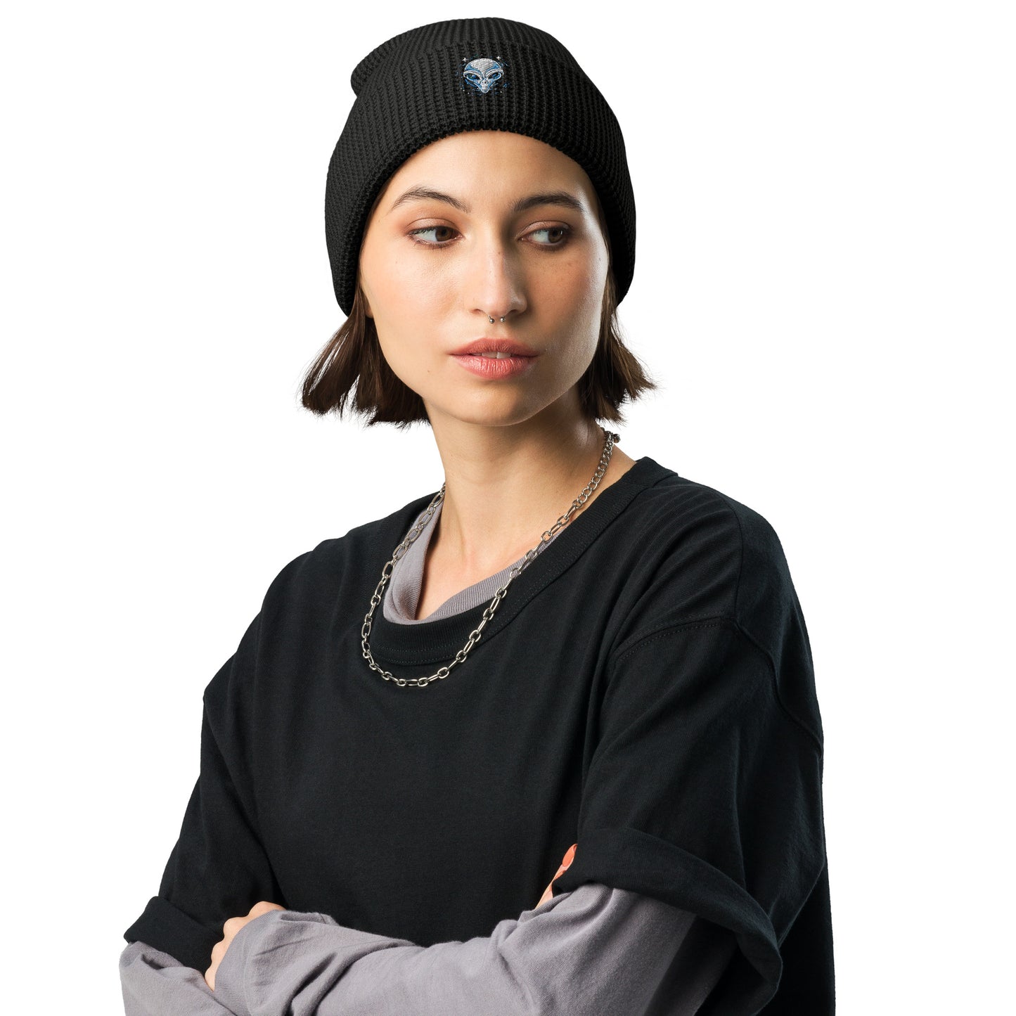 Black alien embroidery waffle beanie worn by woman with layered black and gray shirts