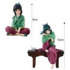 LuckeLadybug anime figure of a girl sitting on a table, dressed in green and maroon attire
