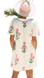 Back view of an apricot floral mini dress by LuckeLadybug with pink flowers and green leaves