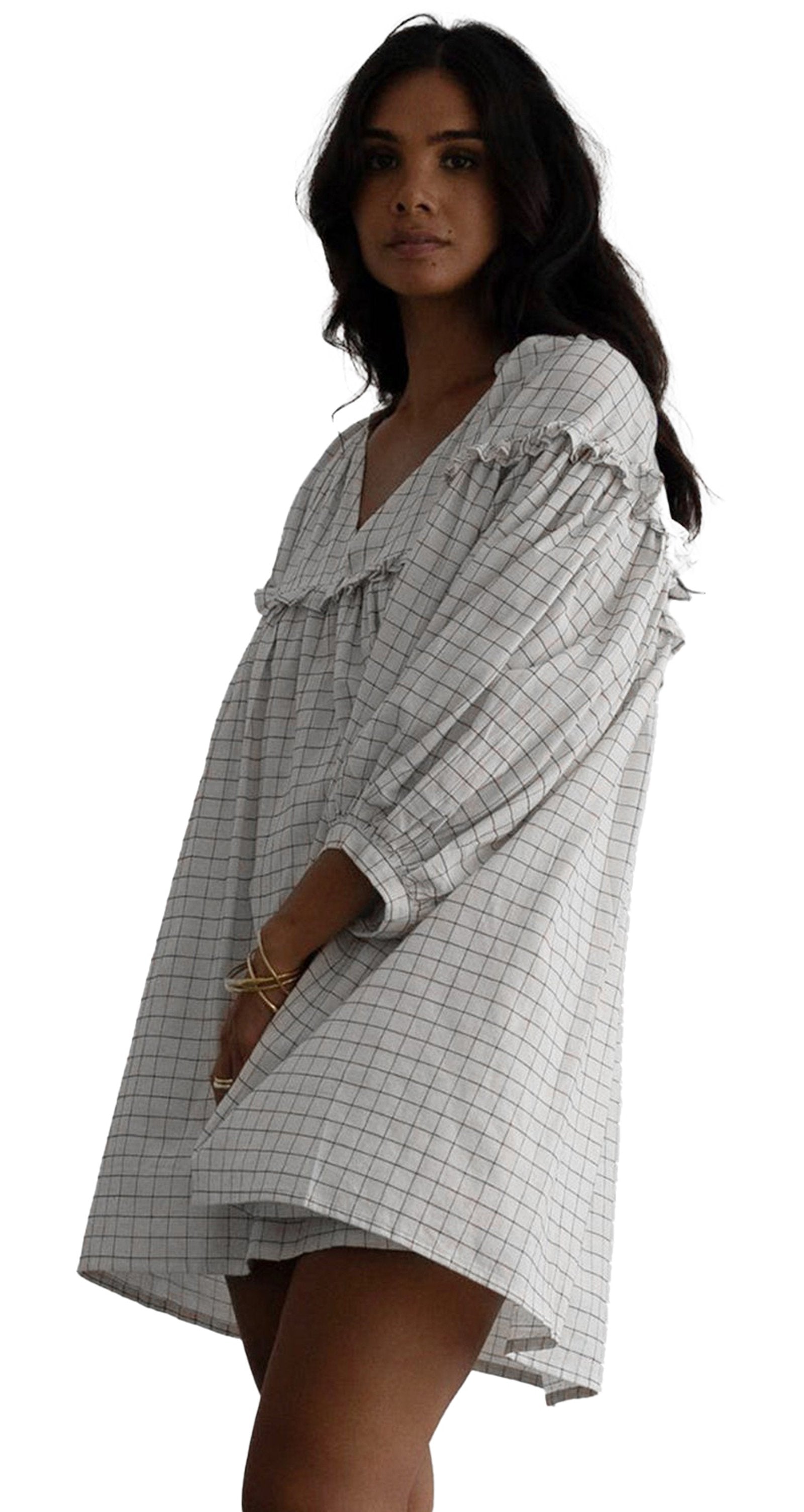 Model wearing white checkered babydoll dress with V neck puff sleeves and relaxed mini silhouette